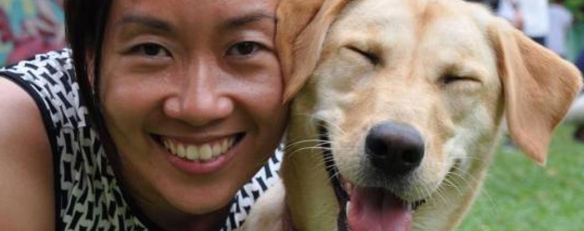 A woman 和 a service dog smiling at the camera.